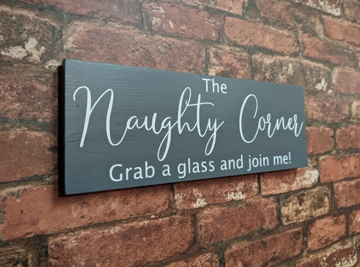 Naughty Corner sign on a brick wall.