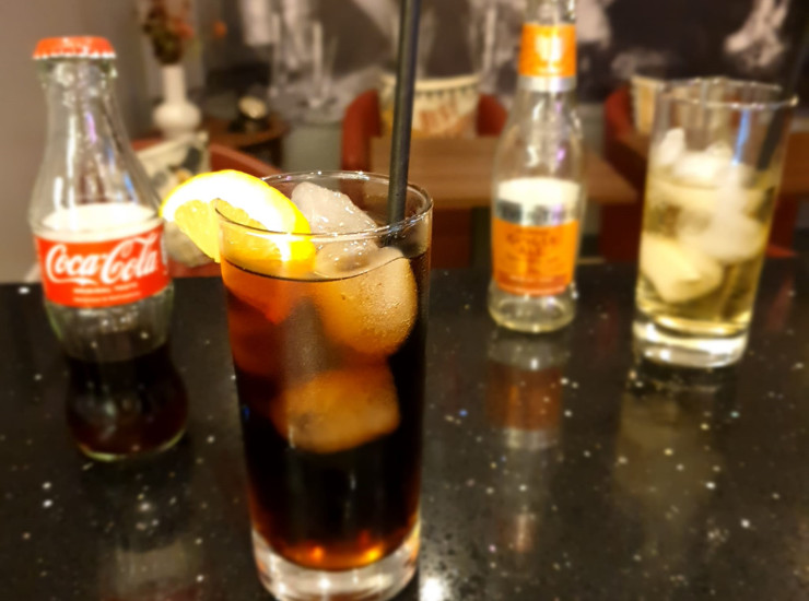 Coca-Cola and Ginger Ale soft drinks on a counter top in a bar.