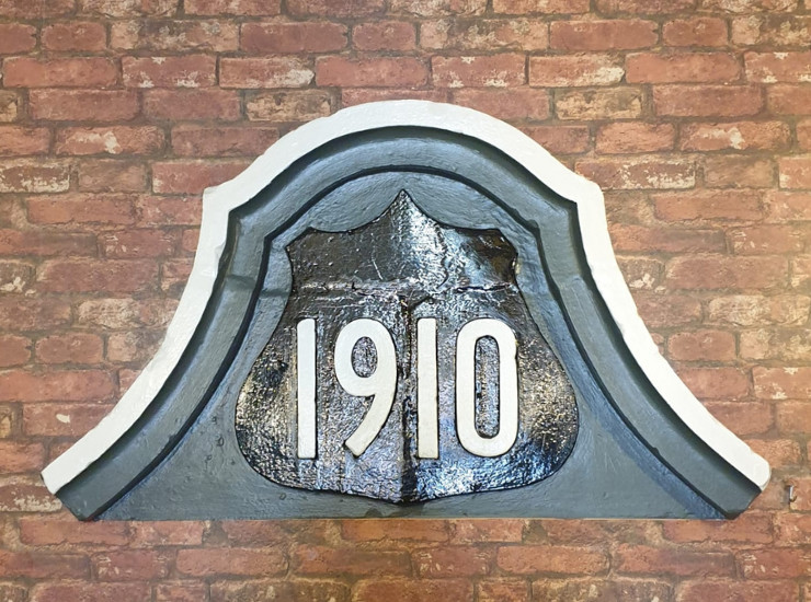 Original 1910 sign placed on the wall of the seating are within the 1910 cocktail bar.